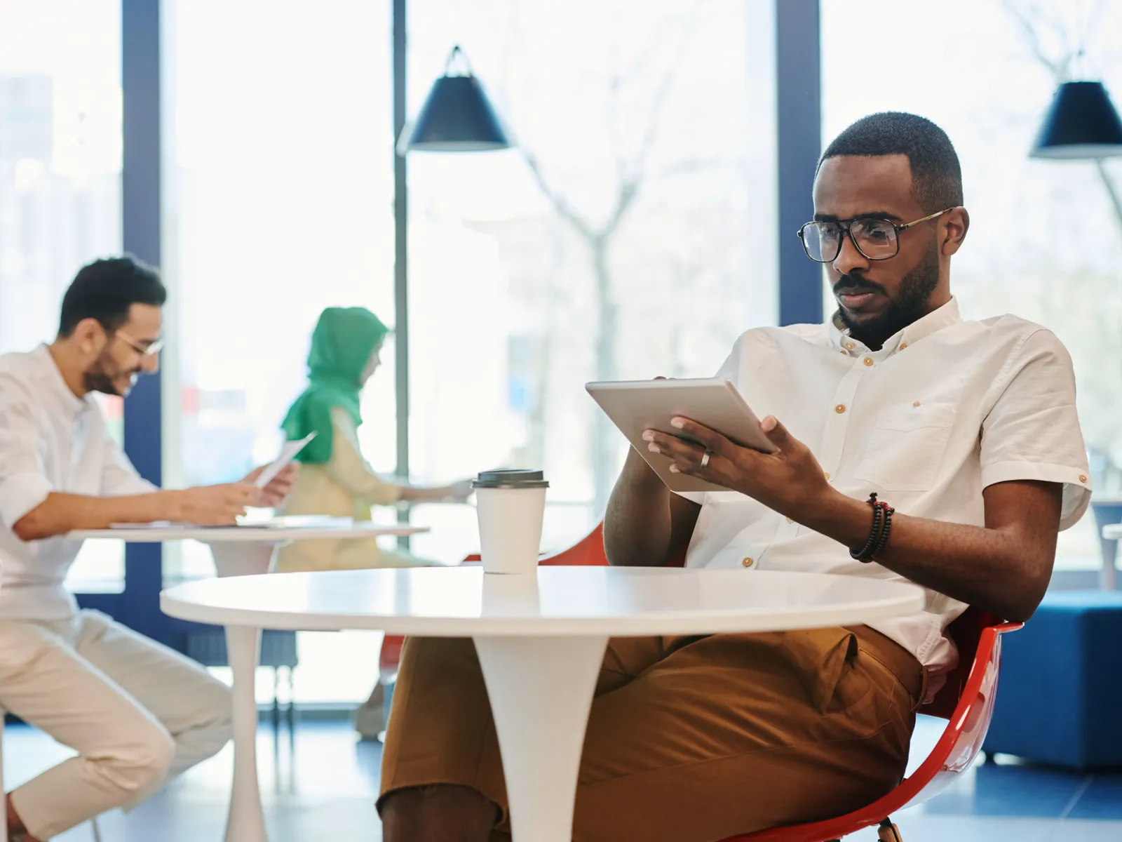 Advisor reading a meeting summary on a tablet at a small table after a call