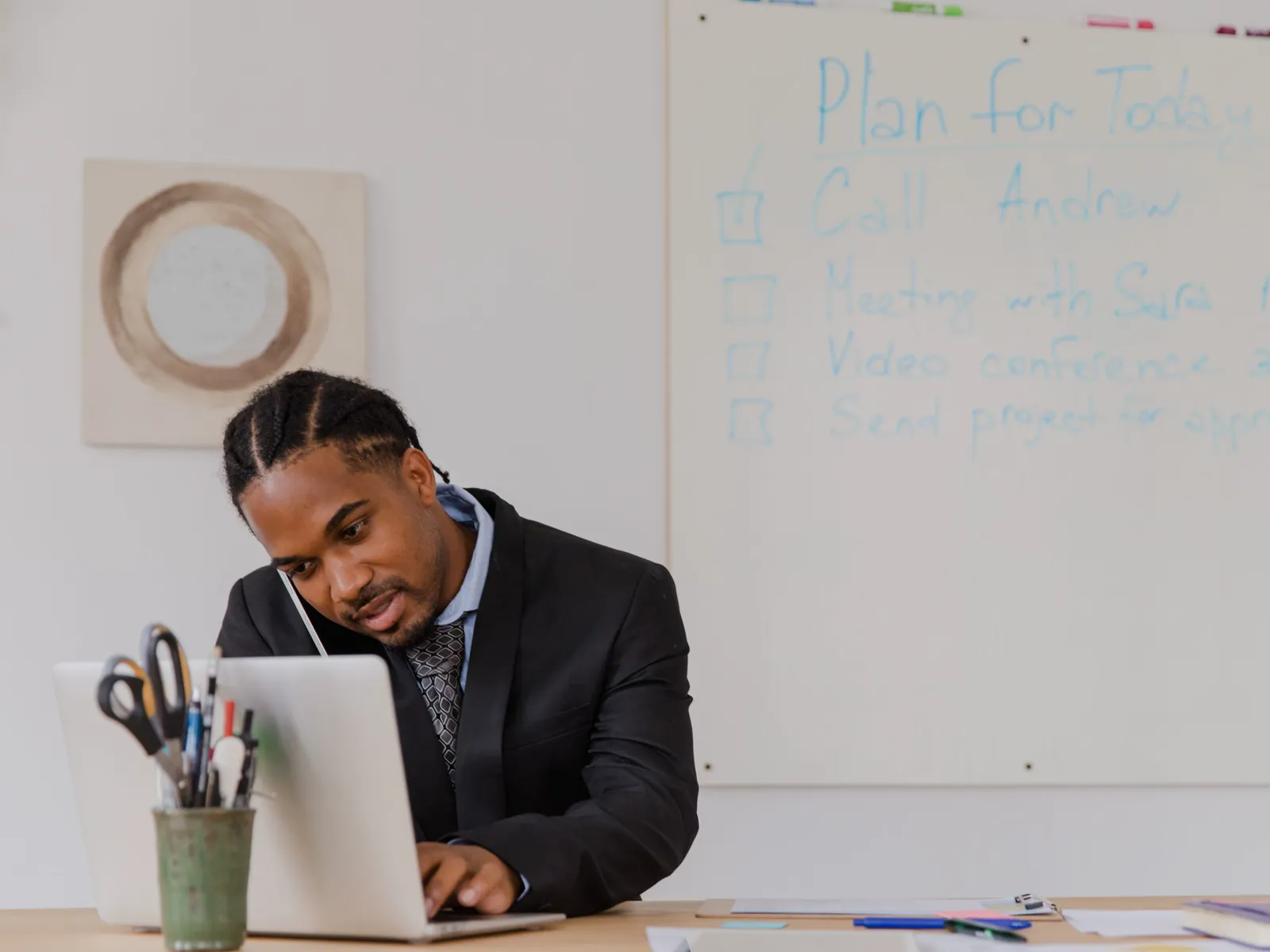 Advisor at his desk speaking through a client conversation beside an open laptop